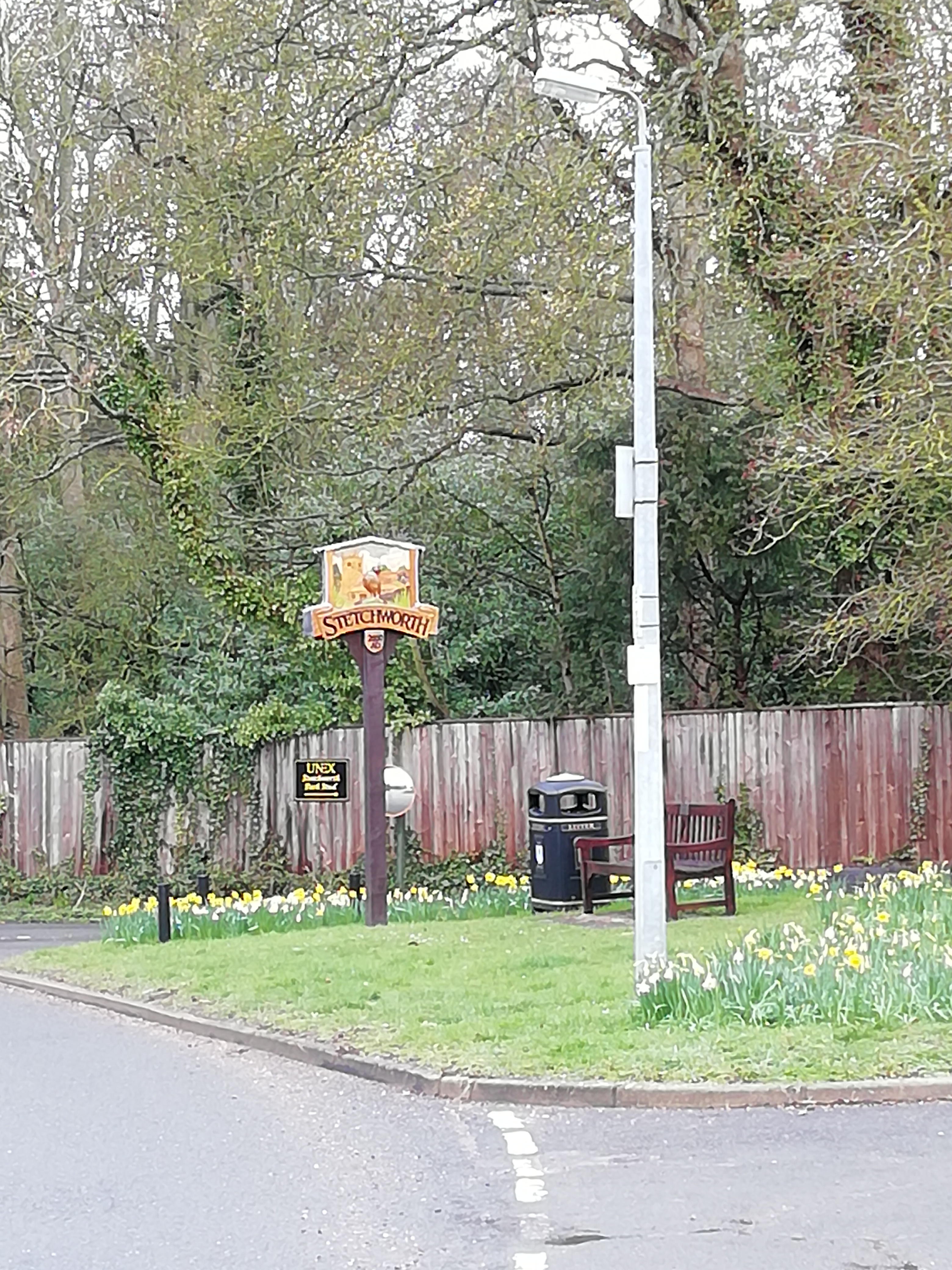 Village green showing village sign, bench & litter bin